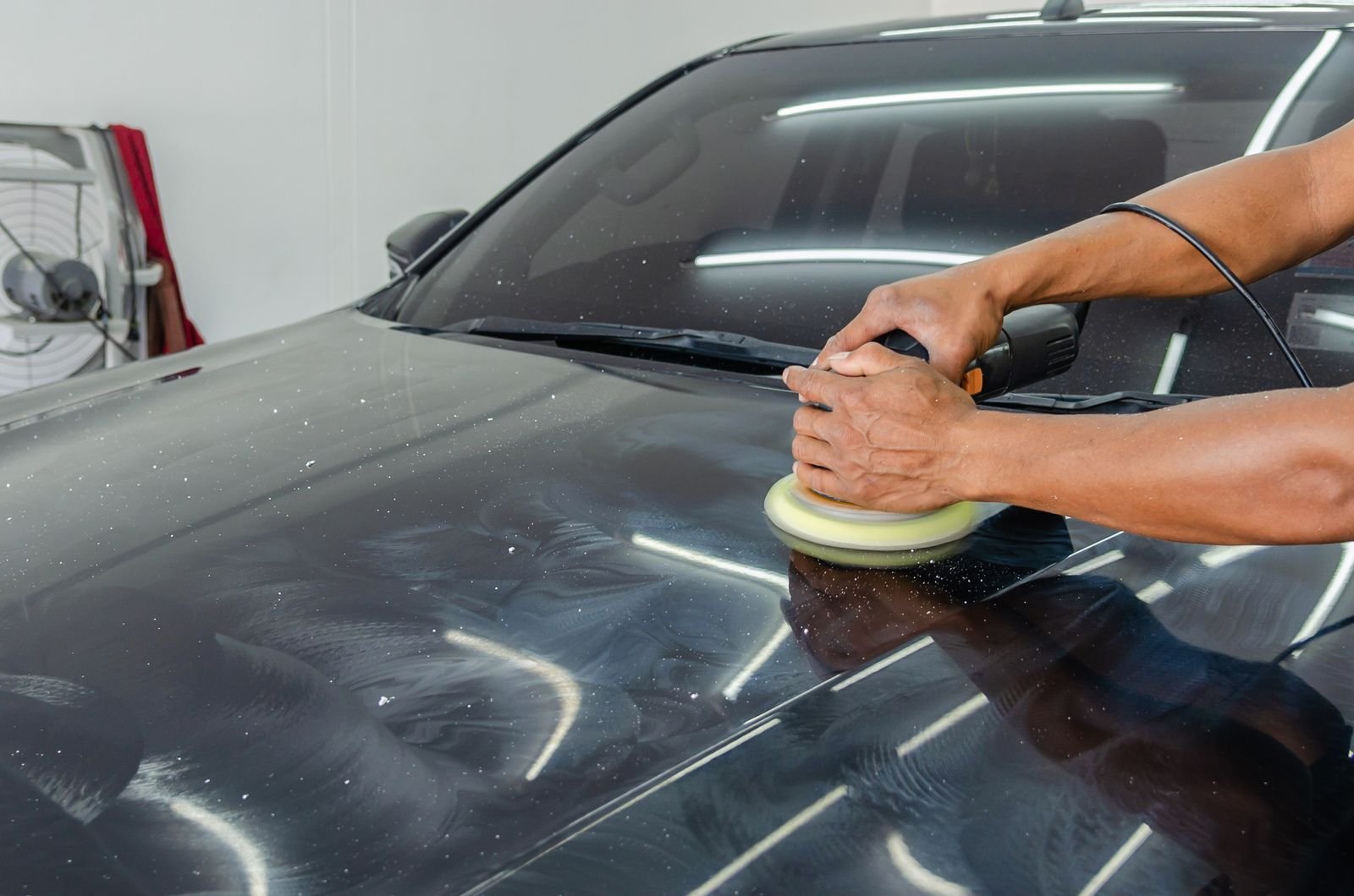 Profissional polindo a lataria de um carro preto
